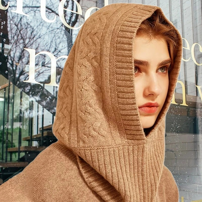 Femme portant une élégante cagoule capuche en laine beige avec un design torsadé, idéale pour un look chic et une protection contre le froid.