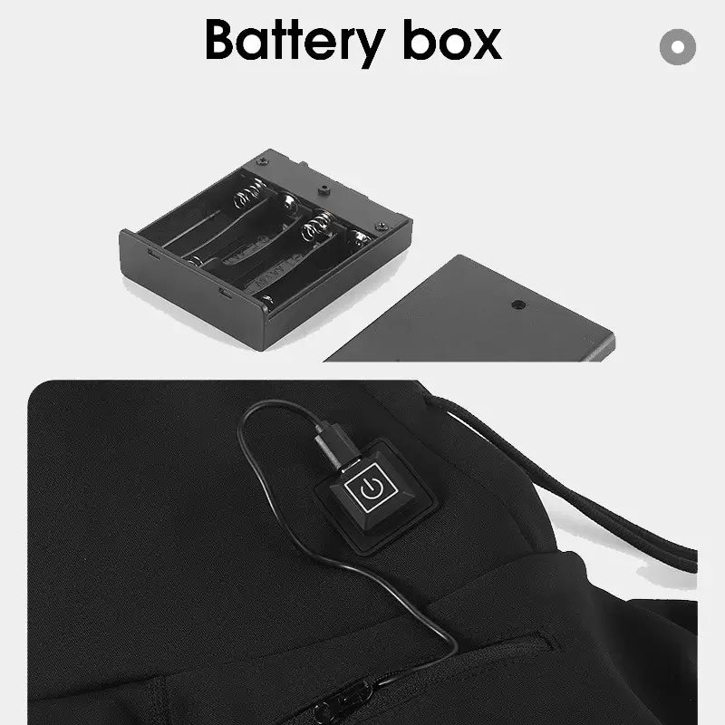 Boîtier à piles pour cagoule chauffante noire, présentant un compartiment pour 4 piles et un bouton d'alimentation connecté à la cagoule. L'image met en avant la facilité d'utilisation du système de chauffage via une connexion électrique pratique et sécurisée. Idéal pour les activités hivernales et les environnements froids.