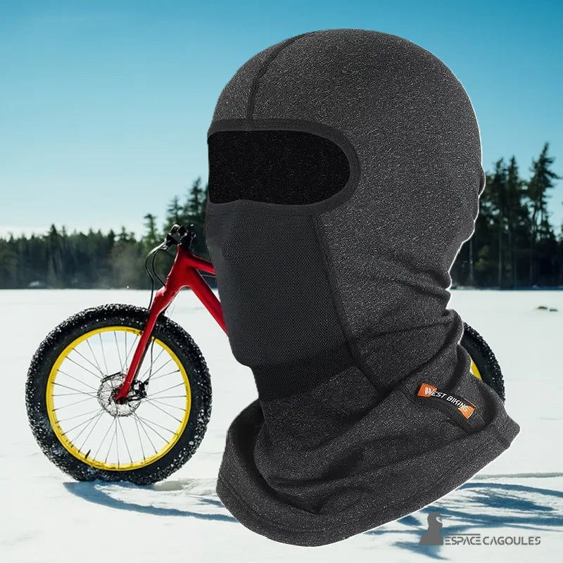 Svart cykelbalaklava med andningsbar panel på snötäckt bakgrund och röd cykel i bakgrunden – Espace Cagoules