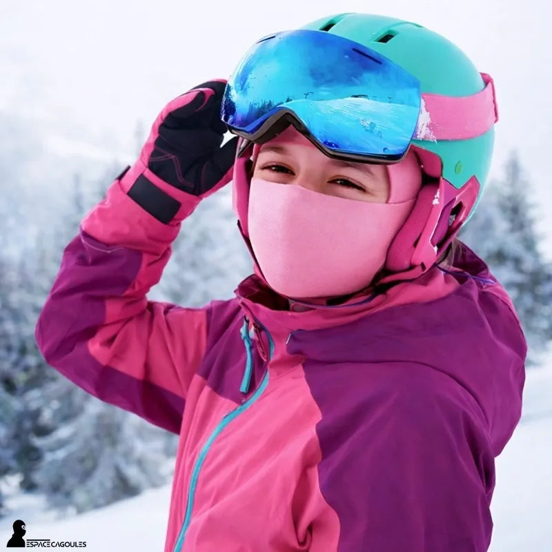 Cagoule de ski enfant SnowKid portée par une enfant avec casque de ski et masque sur une piste enneigée vue rapprochée – Espace Cagoules