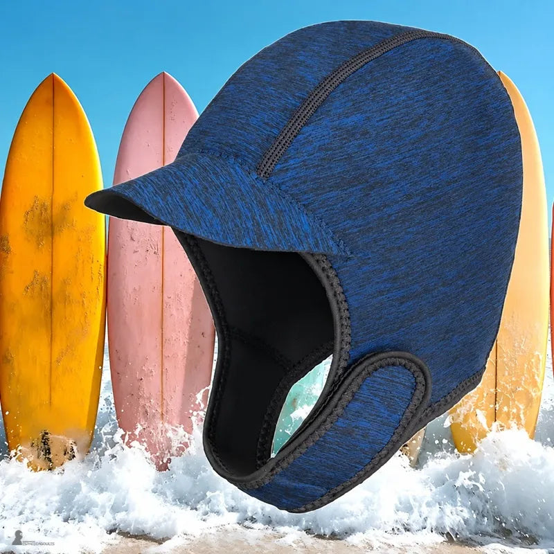 Cagoule de surf CapSurf bleu navy portée près des vagues sur la plage - Espace Cagoules