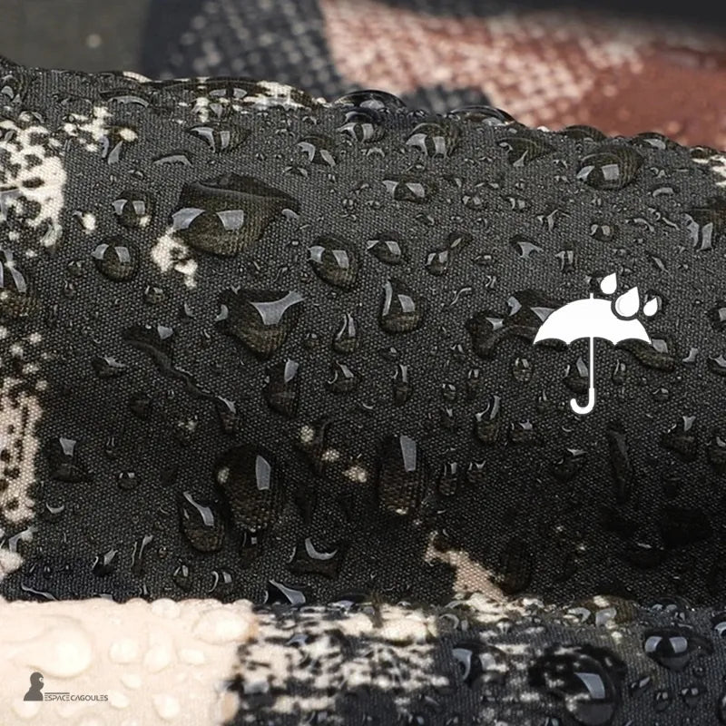 Cagoule de chasse en tissu camouflage déperlant, gros plan montrant les gouttes d’eau en surface et le traitement hydrophobe du textile.