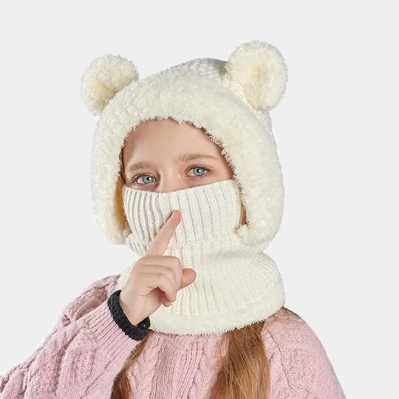 Cagoule enfant fille blanche avec des oreilles d'ours, en tricot doux, couvrant le visage pour protéger du froid, portée par une enfant avec une tenue rose.