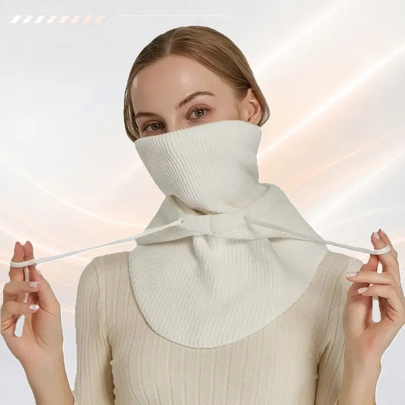 Cagoule femme blanche portée col montant remonté sur le bas du visage, pans avant sur le buste et cordons de serrage tenus à deux mains - Espace Cagoules