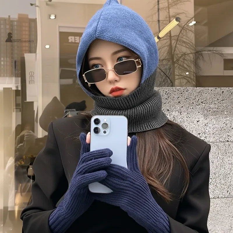 Cagoule femme en laine bleu et gris portée en ville avec lunettes et gants assortis, couvrant tête et cou en hiver