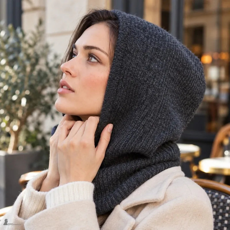 Femme de profil, mains au col de la cagoule Silverine gris foncé, capuche couvrant la tête et le cou sur un manteau beige - Espace Cagoules