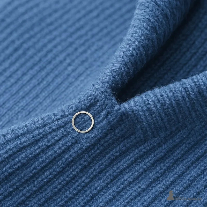 Cagoule Femme Tendance zoom sur le bouton pression argenté fixé sur la maille bleue à l’avant du cou