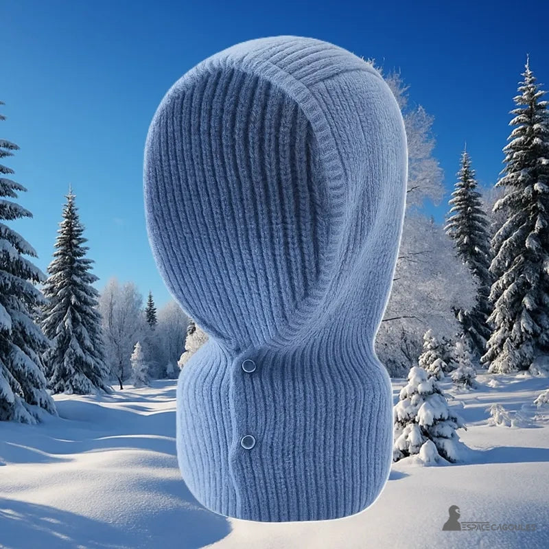 Cagoule Femme Tendance en laine bleue exposée sur fond de paysage hivernal, parfaite pour rester stylée par temps froid