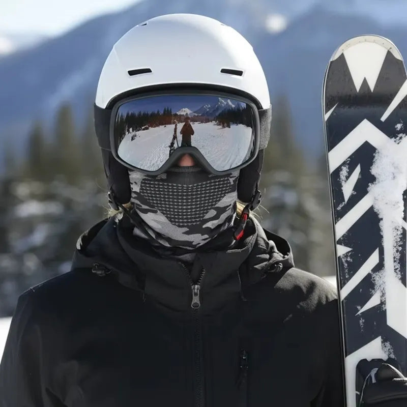 Cagoule fine sous casque de ski camouflage gris portée par un skieur en casque blanc et masque, tenant ses skis en montagne enneigée - Espace Cagoules