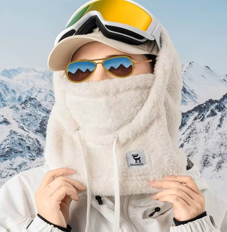 Cagoule fleece blanche avec capuche ajustable et doublure douce, idéale pour les sports d'hiver et les activités en montagne.