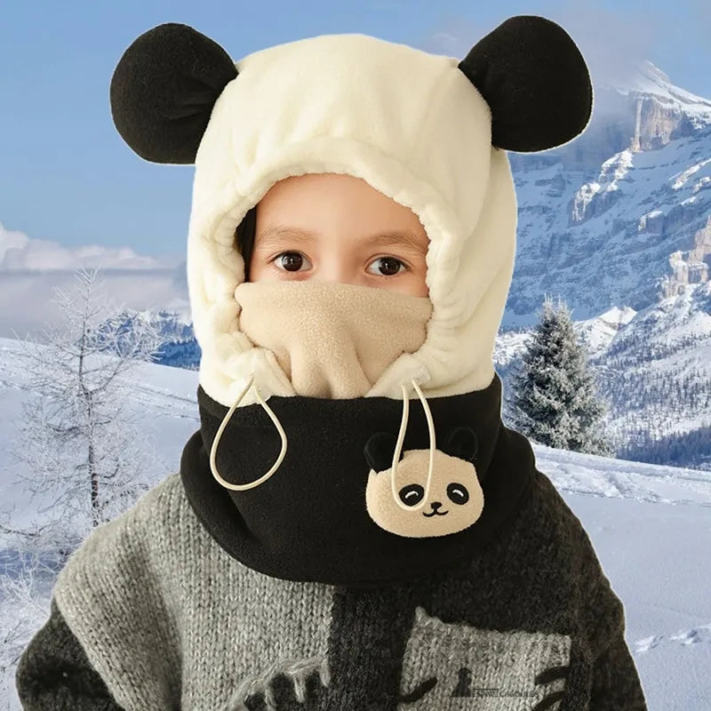 Cagoule grand froid enfant blanche et noire avec oreilles rondes et décor panda, portée dans un paysage montagneux enneigé pour protection optimale.