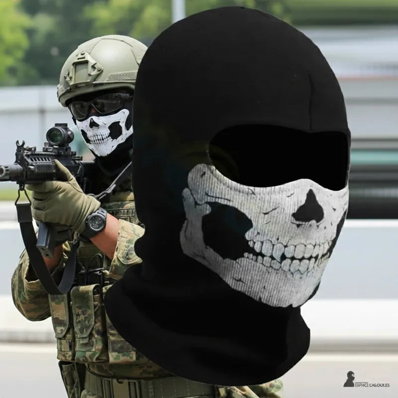 Cagoule Militaire Tête de Mort noire avec motif crâne blanc sur la partie faciale, vue produit en gros plan avec un soldat équipé en arrière-plan tenant une arme – Espace Cagoules