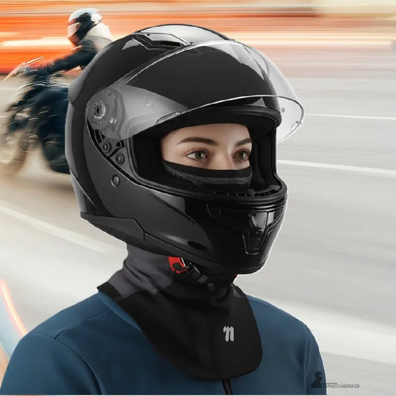 Cagoule moto hiver à plastron portée par une femme sous casque intégral, textile technique avec doublure polaire, forme couvrante ajustée, vue portée en situation de conduite - Espace Cagoules