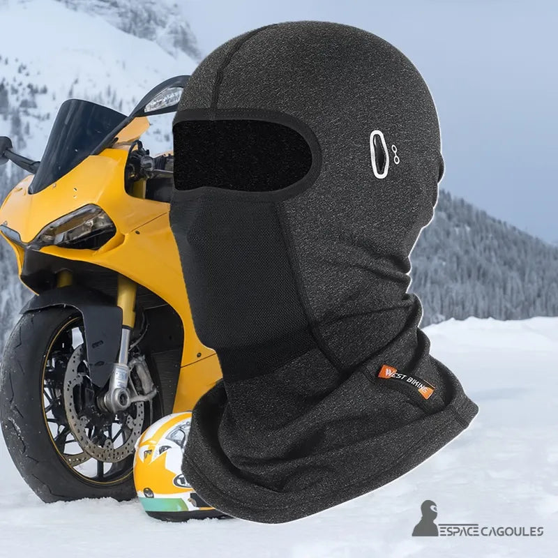 Cagoule Casque Moto - Cagoule grise portée en montagne devant une moto jaune, idéale pour l’hiver
