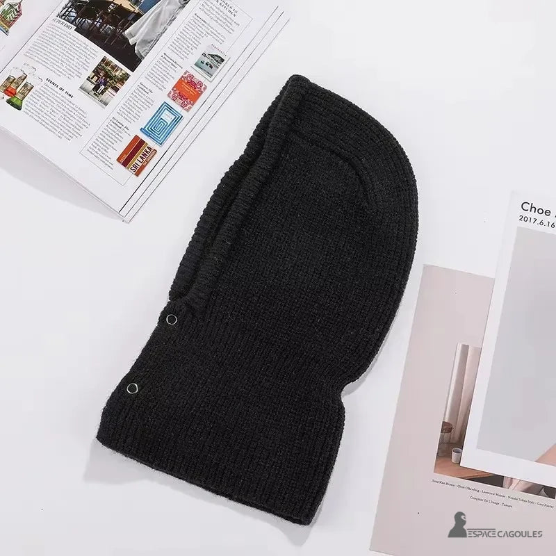 Cagoule Noire Femme présentée à plat sur fond blanc avec magazines, dévoilant sa forme ergonomique et ses finitions nettes