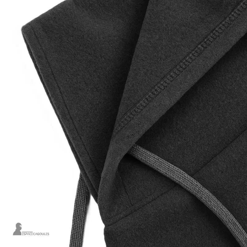 Cagoule par dessus casque ski avec zoom sur les coutures plates et cordons de serrage, détail de finition précise sur tissu polaire chaud