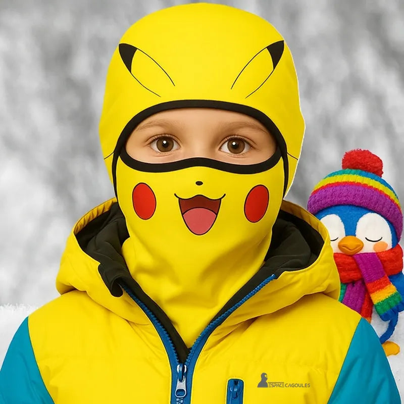 Cagoule Pikachu enfant portée avec blouson de ski jaune et bleu, ambiance hivernale avec décor enneigé et pingouin coloré