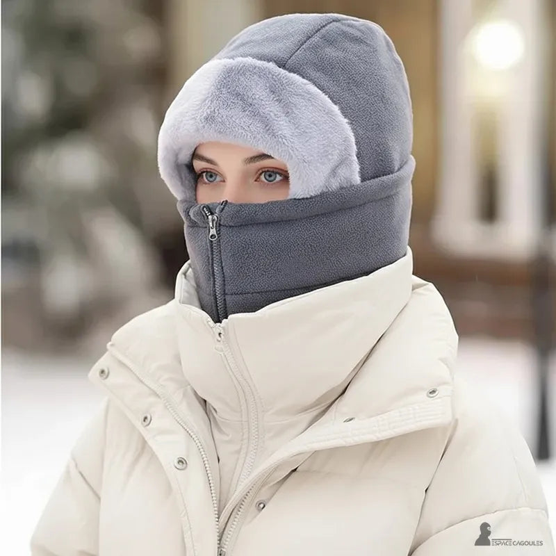 Cagoule femme polaire a zip frontal gris foncé portée par une femme en manteau blanc dans un décor hivernal - Espace Cagoules