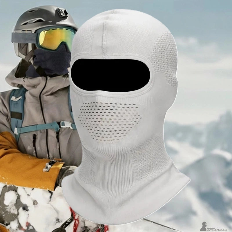 Atmungsaktive weiße Skimaske, frontalansicht mit perforierter Zone über dem Mund, überlagert vor einem Skifahrer in schneebedeckten Bergen - Cagoules Bereich