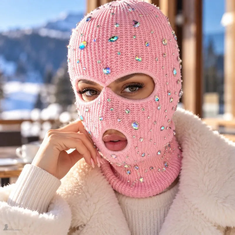 Femme portant la cagoule strass rose Strassia et un manteau en fausse fourrure sur une terrasse face aux montagnes enneigées - Espace Cagoules