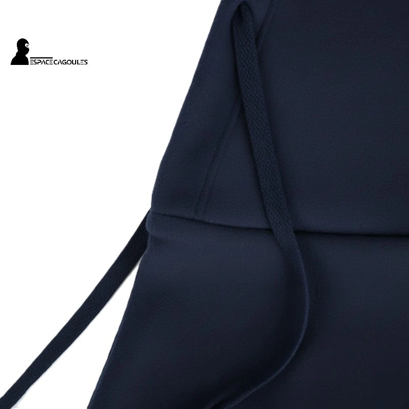 Cagoule sur Casque en tissu polaire marine, gros plan sur les cordons de serrage et les coutures de finition.