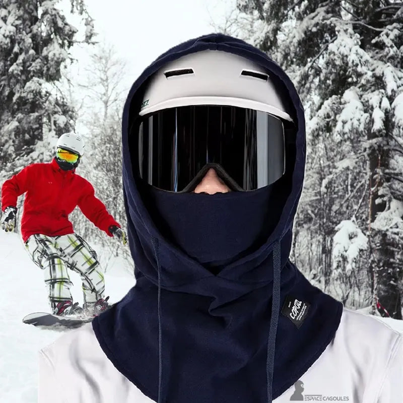 Cagoule sur Casque utilisée en snowboard dans un environnement de montagne enneigée, protection optimale contre le froid hivernal.