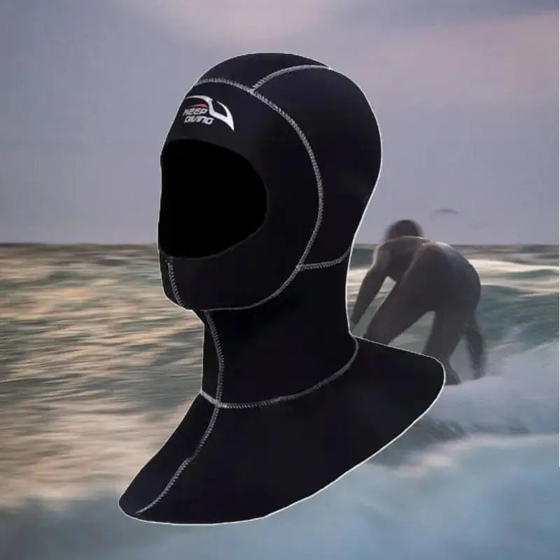 Surfeur prenant une vague en mer froide à côté d'une cagoule surf hiver néoprène noire à couture blanche - Espace Cagoules