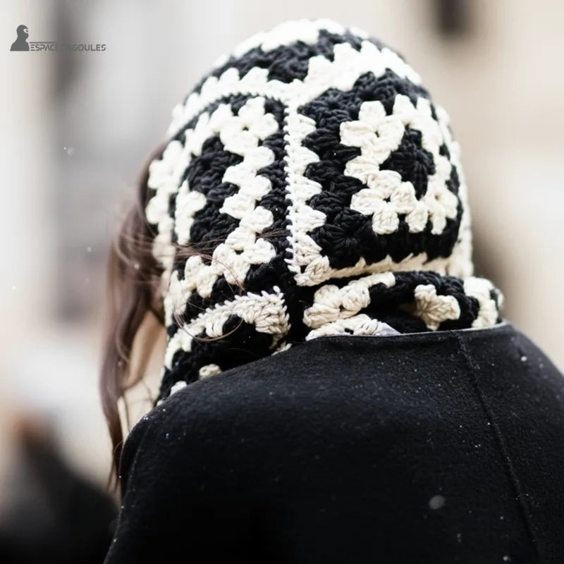 Cagoule tour de cou femme crochet noir et blanc vue de dos et portée en extérieur urbain sous la neige avec manteau chic