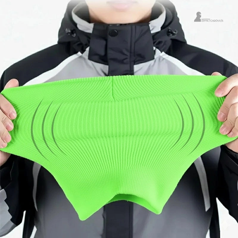 Passamontagna verde fluo – dimostrazione di elasticità, Passamontagna tenuta con entrambe le mani davanti a una giacca tecnica per mostrare l'ottima flessibilità del tessuto – Spazio Passamontagna