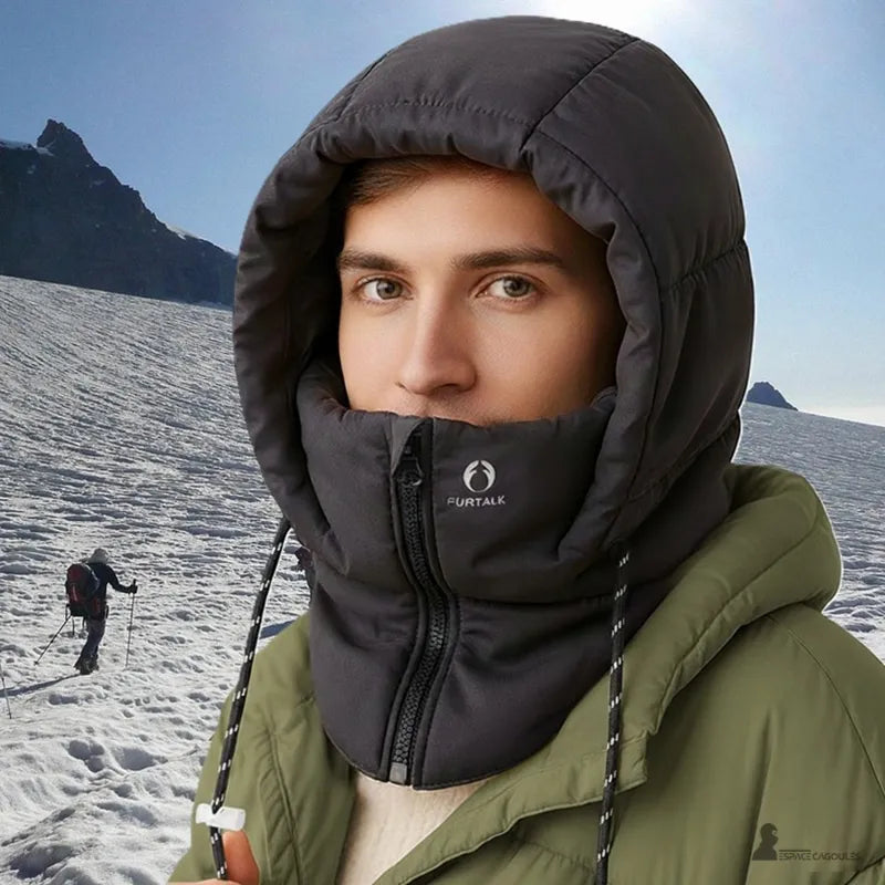 Cagoule waterproof portée en montagne par temps froid, matière extérieure imperméable et doublure polaire, forme enveloppante couvrant tête et cou, vue portée en environnement enneigé - Espace Cagoules