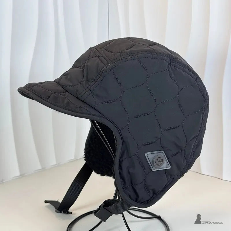 Casquette Chapka matelassée vue détaillée noire posée sur support, oreillettes épaisses et tissu matelassé - Espace Cagoules