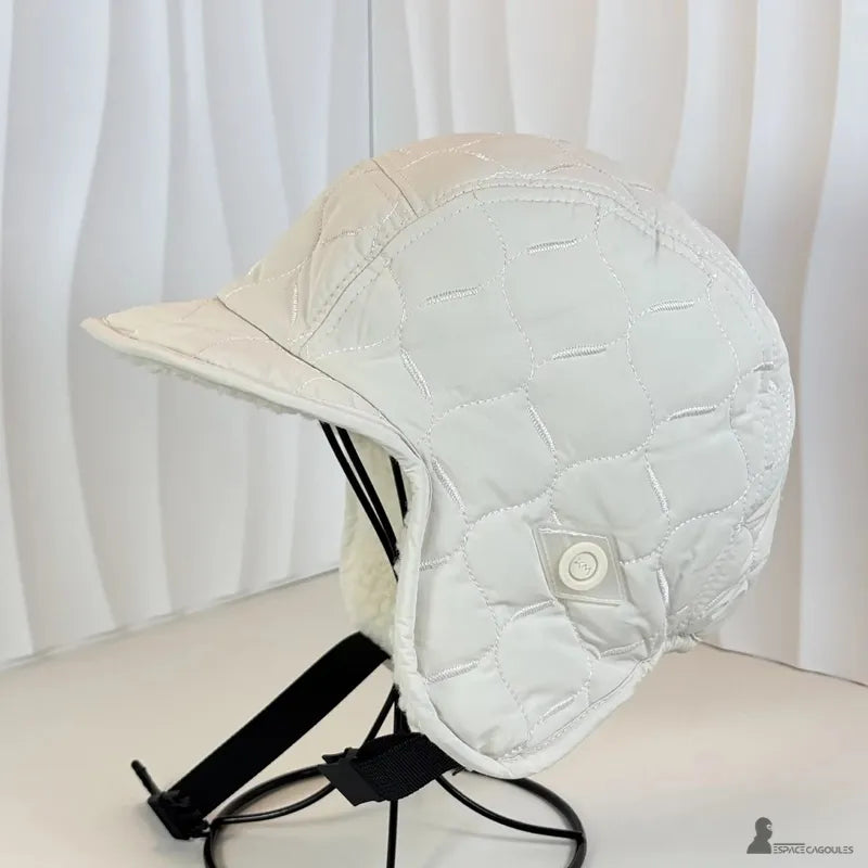 Casquette Chapka matelassée blanche sur support studio, vue latérale montrant tissu capitonné et sangle réglable - Espace Cagoules