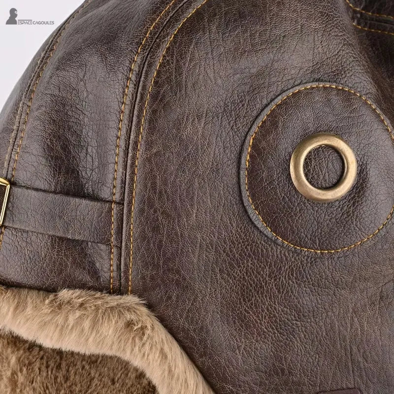 Chapka aviateur en cuir texturé marron avec doublure en fausse fourrure, détail du côté droit et des coutures - Espace Cagoules