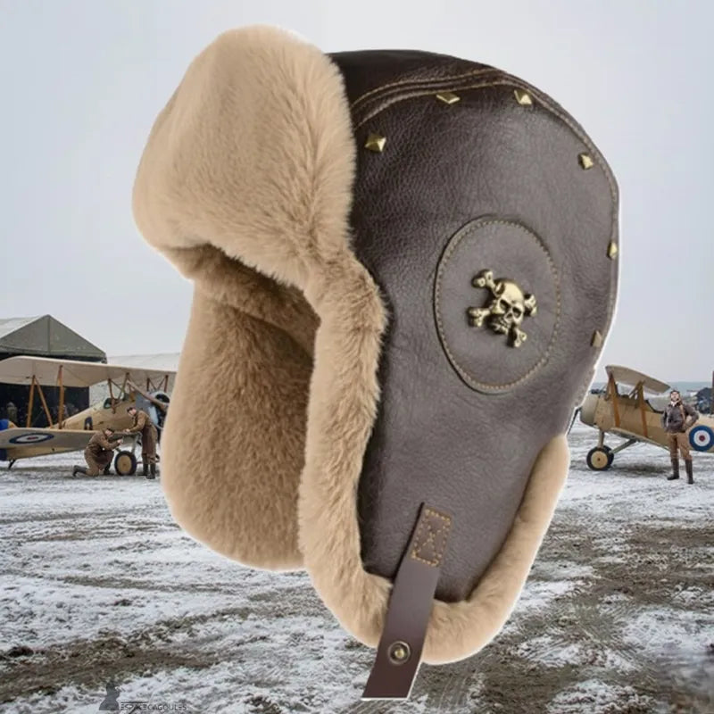 Chapka aviateur en cuir marron avec doublure en fausse fourrure, forme chapka aviateur vue de profil, ambiance historique avec avions anciens en arrière-plan - Espace Cagoules