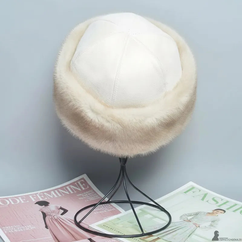 Faux fourrure Chapka in beiger Kunstfell mit weißem Oberteil, runde Chapka-Form, Draufsicht auf Ständer, in neutralem Innenraum - Cagoules Raum