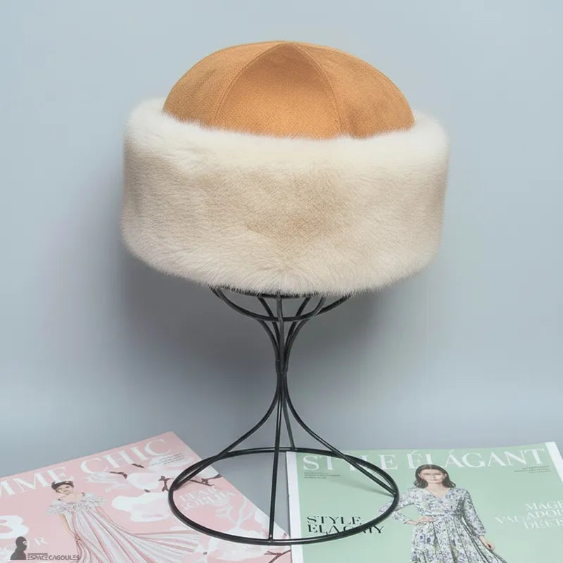 Faux fourrure Chapka in beiger Kunstfell mit camel-farbenem Oberteil, klassische Chapka-Form, Frontalansicht auf Ständer, präsentiert in einem Innenraum vor hellem Hintergrund - Espace Cagoules.
