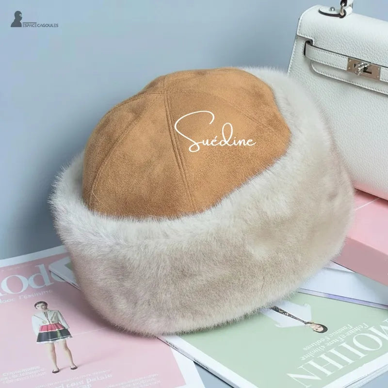 Faux fourrure Chapka in heller Kunstfell mit beigem Wildleder-Innenfutter, elegante Chapka-Form, dreiviertel Ansicht, in einem Innenraum mit sichtbaren Accessoires präsentiert - Cagoules Raum.