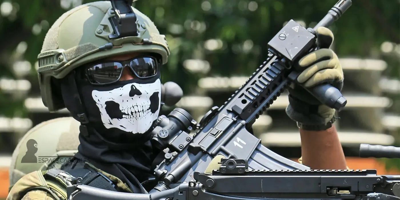 Cagoules tête de mort portées avec casque militaire vert et lunettes noires, motif crâne blanc couvrant nez et bouche, vue rapprochée en extérieur avec fond flou - Espace Cagoules