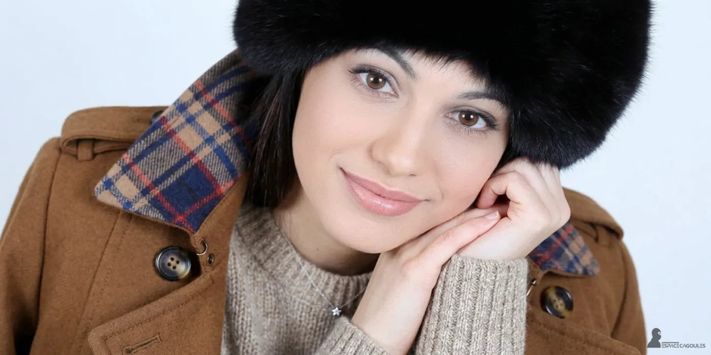 Chapka femme en fourrure noire portée par une femme en manteau marron sur fond clair - Espace Cagoules