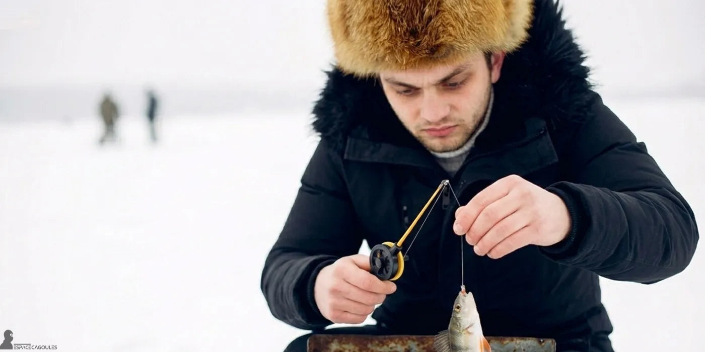Chapka homme en fourrure portée par un homme en veste noire, en train de pêcher sur un lac gelé en hiver - Espace Cagoules
