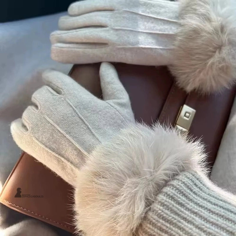 Gants chauds Femme portés et tenant un sac à main chic, pour un hiver fashion et chaud.