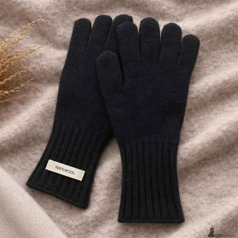 Damenhandschuhe aus natürlicher Wolle in Schwarz, flach liegend, die Schlichtheit und die Verarbeitung des Handgelenks hervorhebend – Cagoules Raum