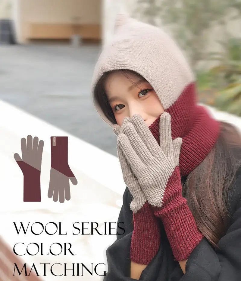 Femme portant un ensemble d'hiver élégant comprenant une cagoule bicolore en laine beige et bordeaux et des Gants Femme en laine idéaux pour l'hiver, parfaits pour un look chic et chaleureux.