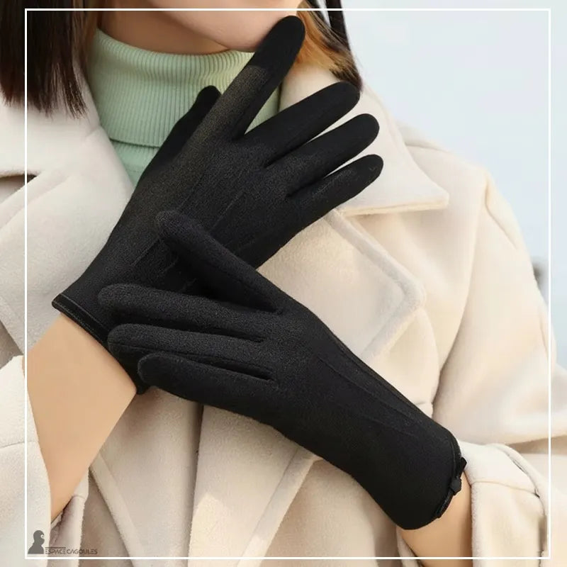 Damenhandschuhe für den Winter, schwarz, aus warmem Textil, lange und enganliegende Passform, an den Händen getragen, Frontalansicht mit hellen Mantel, Außenatmosphäre – Cagoules Raum