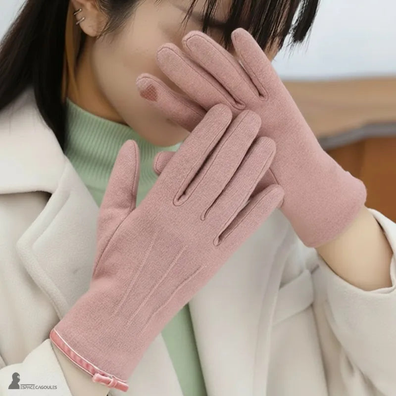 Damenhandschuhe für den Winter in rosa aus weichem Textil, eng anliegend und verlängert, an den Händen getragen, Seitenansicht mit hellen Mantel – Cagoules Raum