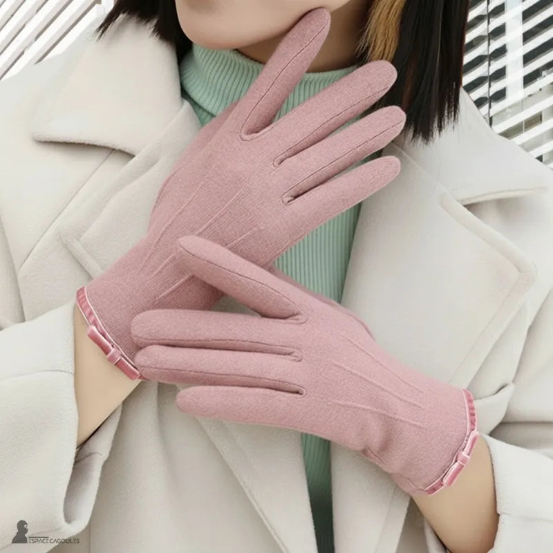 Damenhandschuhe für den Winter in rosa aus weichem Textil, eng anliegend mit feinen Fingern, an beiden Händen getragen, Frontansicht auf einem hellen Mantel im Freien – Cagoules Raum