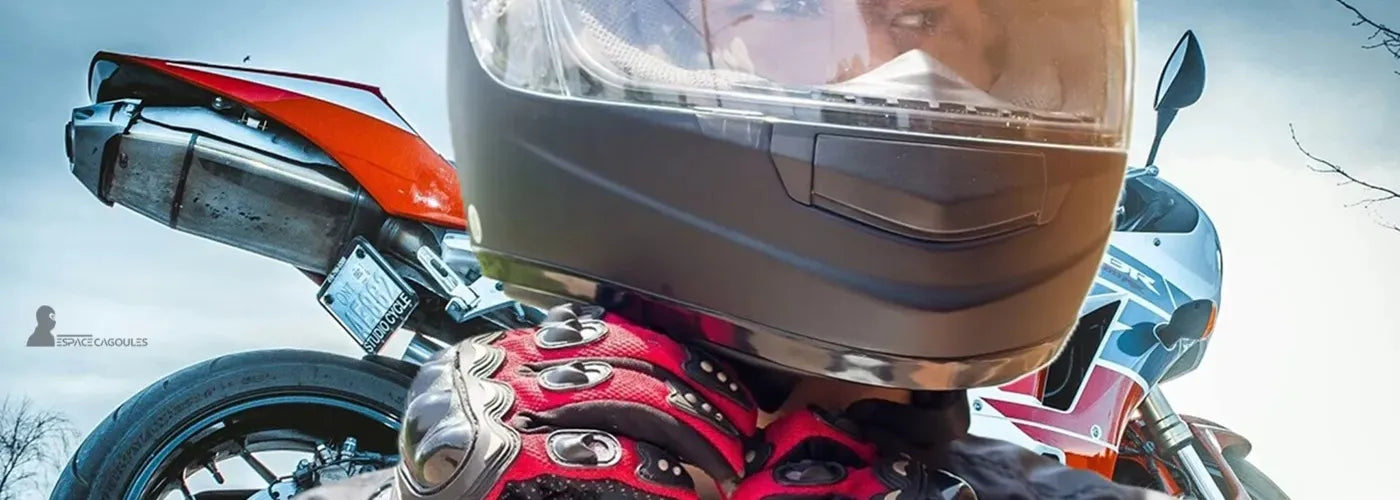 Motard portant un casque intégral et des gants renforcés devant une moto sportive, scène dynamique en extérieur inspirée conduite moto – Espace Cagoules