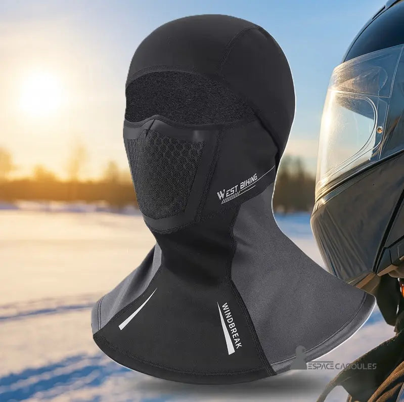 Meilleure Cagoule Moto noire sur fond hivernal avec casque moto posé à droite, idéale pour la conduite par temps froid