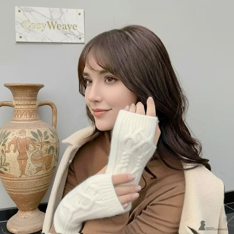 Damenhandschuhe stricken, Frau trägt weiße, gedrehte Handschuhe in einem gemütlichen Innenraum mit dekorativer Vase im Hintergrund - Cagoules Raum