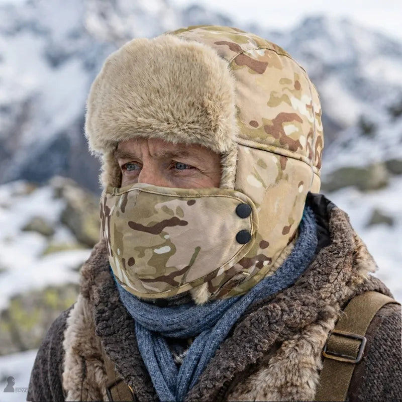 Ouchanka avec masque camouflage désert portée par un homme en extérieur enneigé vue de trois quarts avec masque fixé - Espace Cagoules